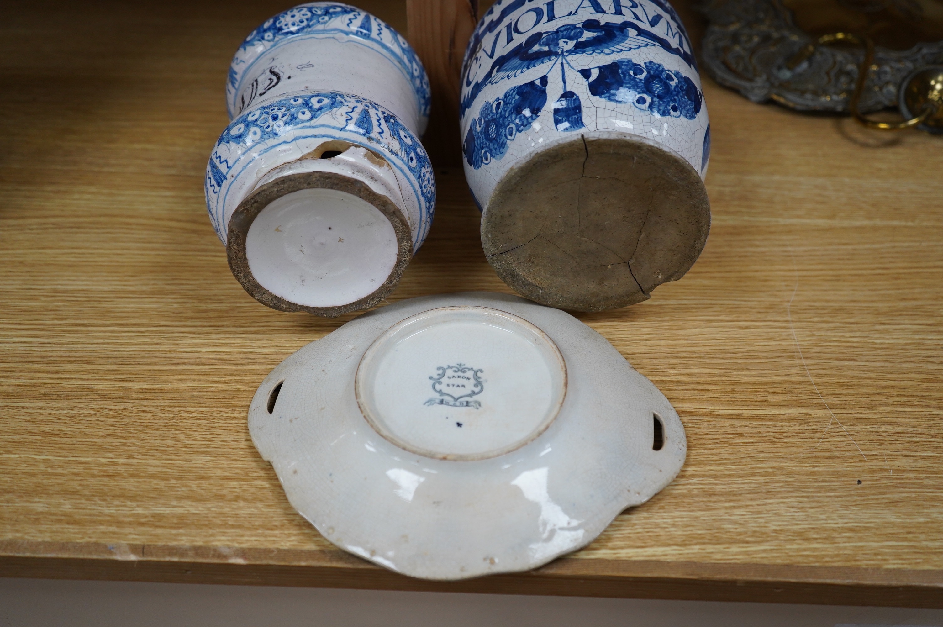 A 17th /18th century blue and white Delft apothecary jar, together with an Italian blue and white pottery drug jar and a blue and white ‘Saxon Star’ two handled dish, tallest 19cm. Condition - poor